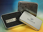 Eleganter USB-Stick in metallischer Optik, verpackt in einer stilvollen Dose mit schwarzem Innenfutter.