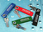 USB-Stick im Schlüssel-Design mit bunten Filzband-Anhängern und Platz für individuelles Firmenlogo.