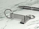 Edelstahl-USB-Stick im modernen Design mit Schlüsselring und Platz für personalisierte Gravuren.