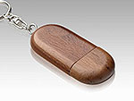 USB-Stick aus dunklem Holz in ovaler Form mit Schlüsselanhänger und Platz für ein individuelles Logo.
