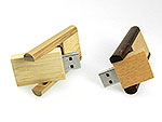USB-Sticks aus hellem und dunklem Holz mit innovativem Ziehmechanismus und Platz für individuelles Logo.