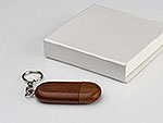 USB-Stick in ovaler Holzoptik mit Schlüsselanhänger und individuellem Platz für Ihr Logo. Präsentiert in einer eleganten Box.