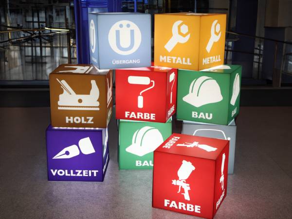 Bunte 40 cm LED Sitzwürfel mit Folierung für Holz, Metall, Farbe, Bau und Vollzeit – eingesetzt als Farbleitsystem in einer Hochschule.