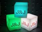 Leuchtende Würfel in verschiedenen Farben mit dem Logo „J&J“ für kreative Werbeaktionen und stimmungsvolle Beleuchtung.